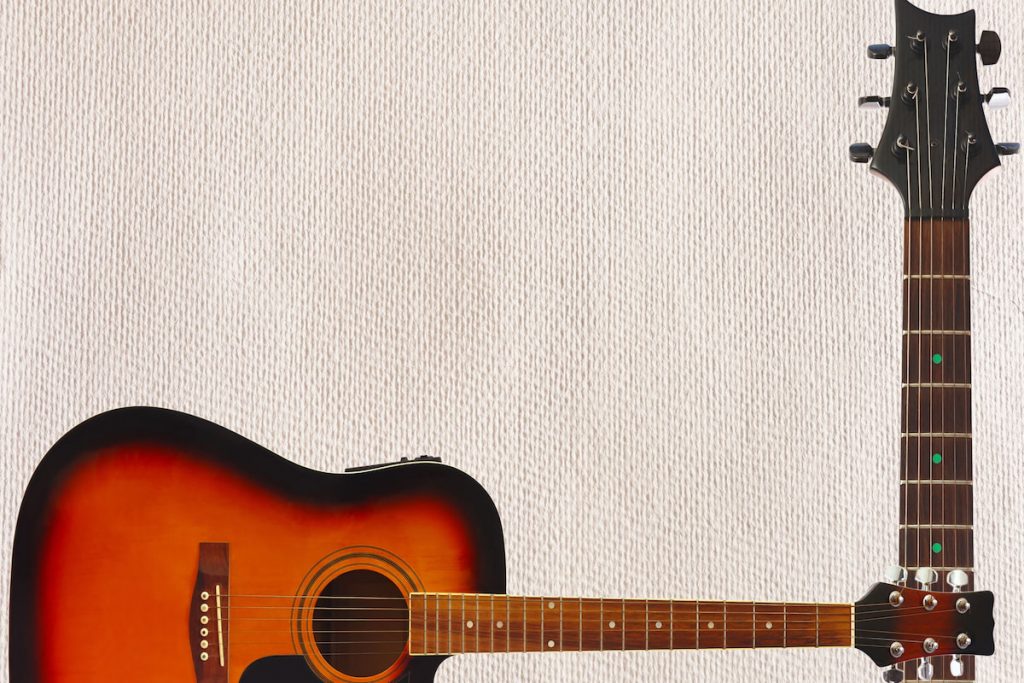 Acoustic jumbo guitar and neck on the cardboard background