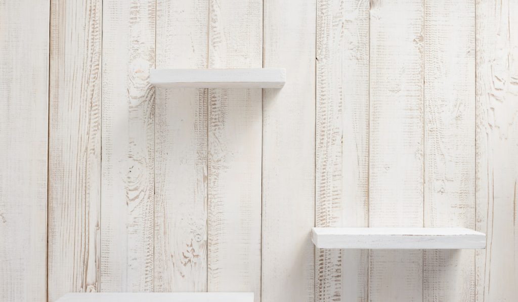 Wooden mini shelves painted with white on white wooden wall