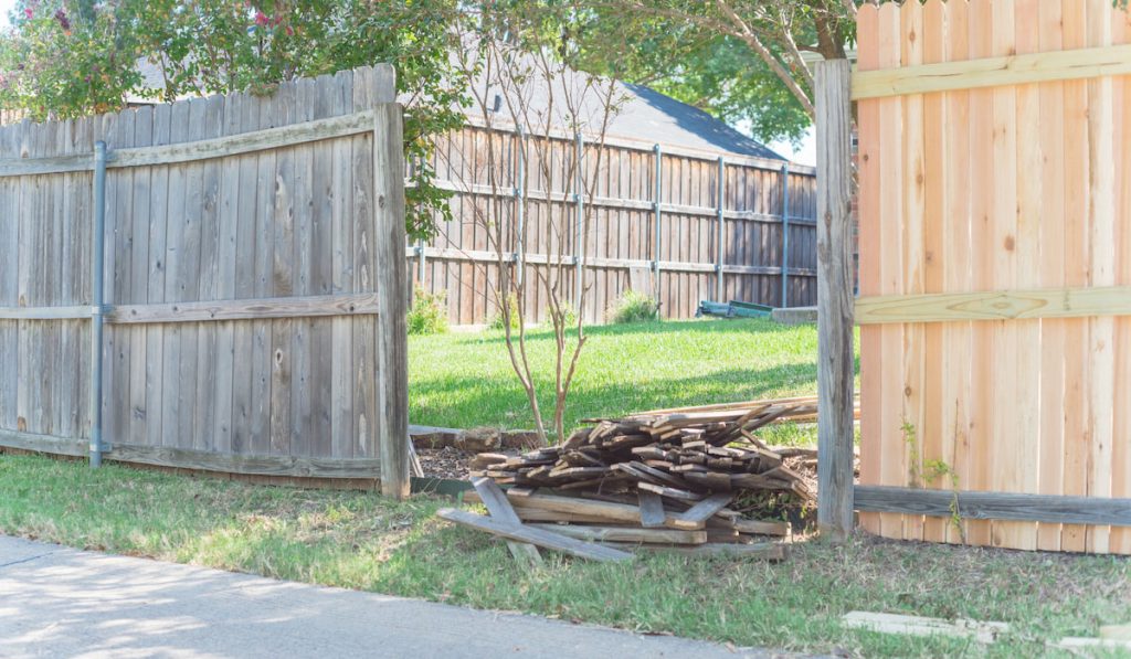 pile of old wooden fence on the ground after replacement of wooden fence at residential neighborhood