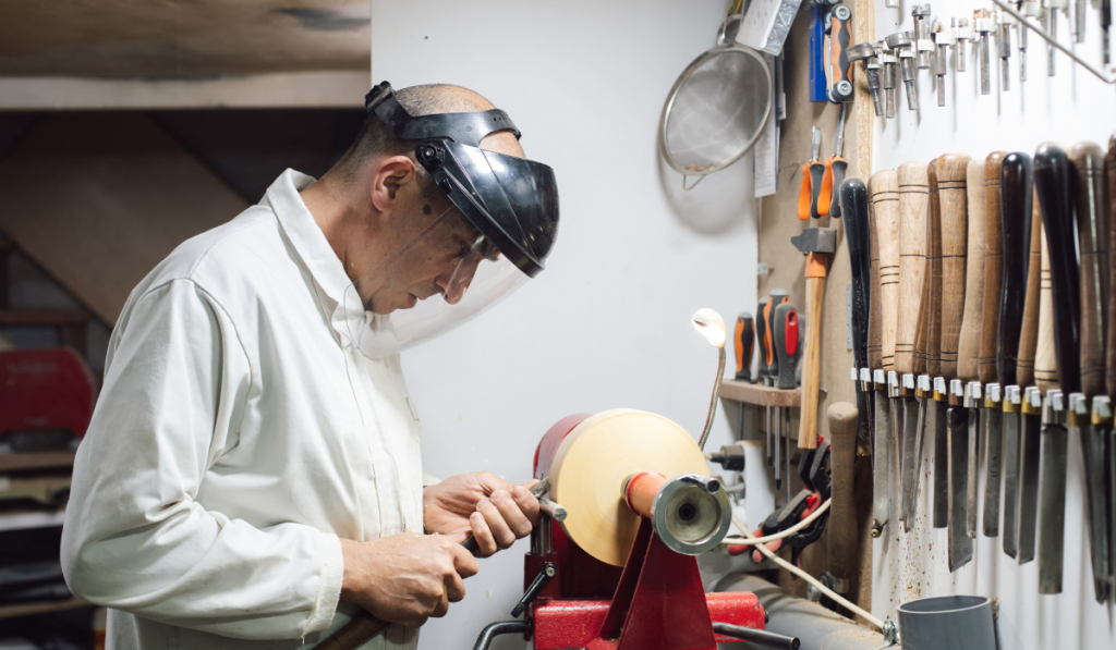 Joinery worker shaping a piece of wood on the lathe
