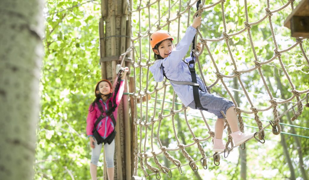 little girls playing in tree top adventure park
