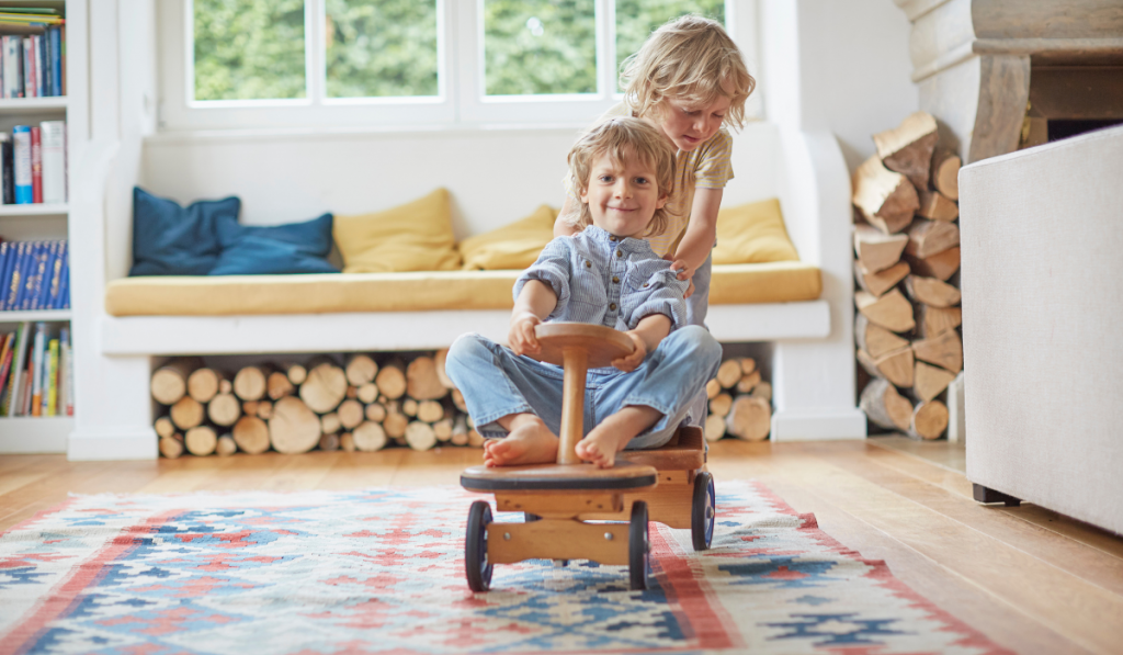 Two young brothers playing with wooden toy car
