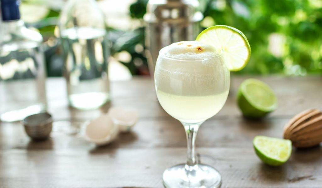 Pisco Sour Cocktail with lime and egg on the table