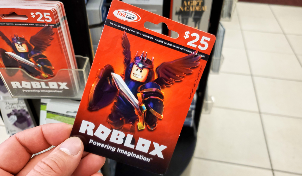 Roblox gift card in a hand over gift cards background