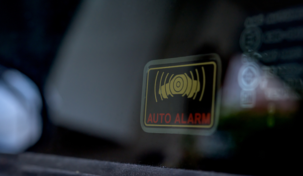 Close up shot of car auto alarm system symbol sticker indicate the active stolen car emergency alarm security system on the side-facing window on a vehicle
