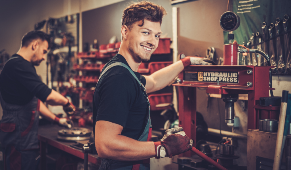 car mechanic working with hydraulic press