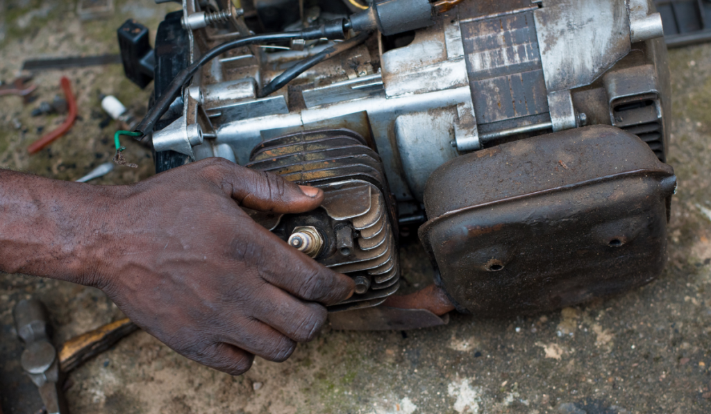 An Engineer working on a small electricity generator in an engineering workshop